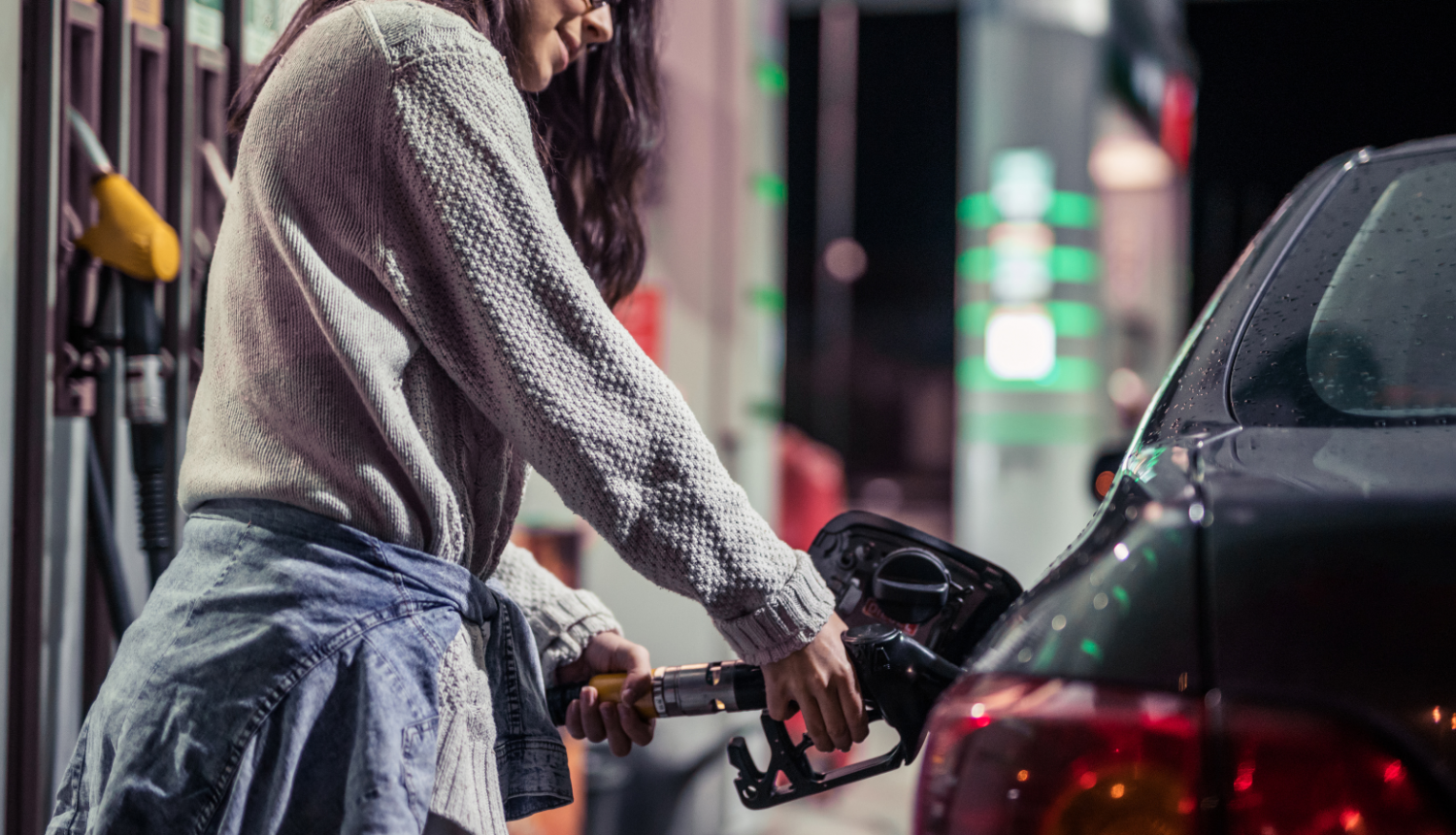Sieviete degvielas uzpildes stacijā pilda degvielu auto