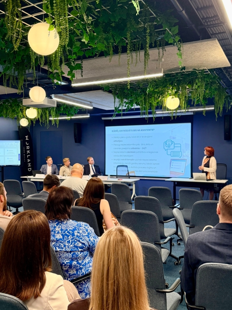 Konferenču zāle ar cilvēkiem, kas sēž krēslos