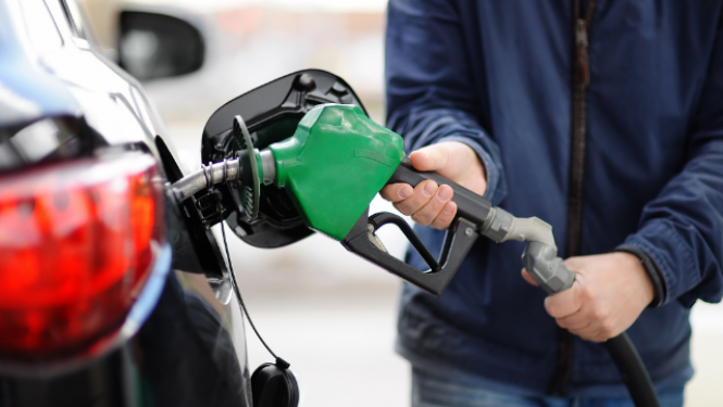 Cilvēks uzpilda auto degvielu