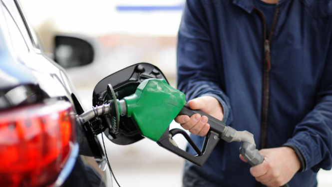 Cilvēks uzpilda auto degvielu