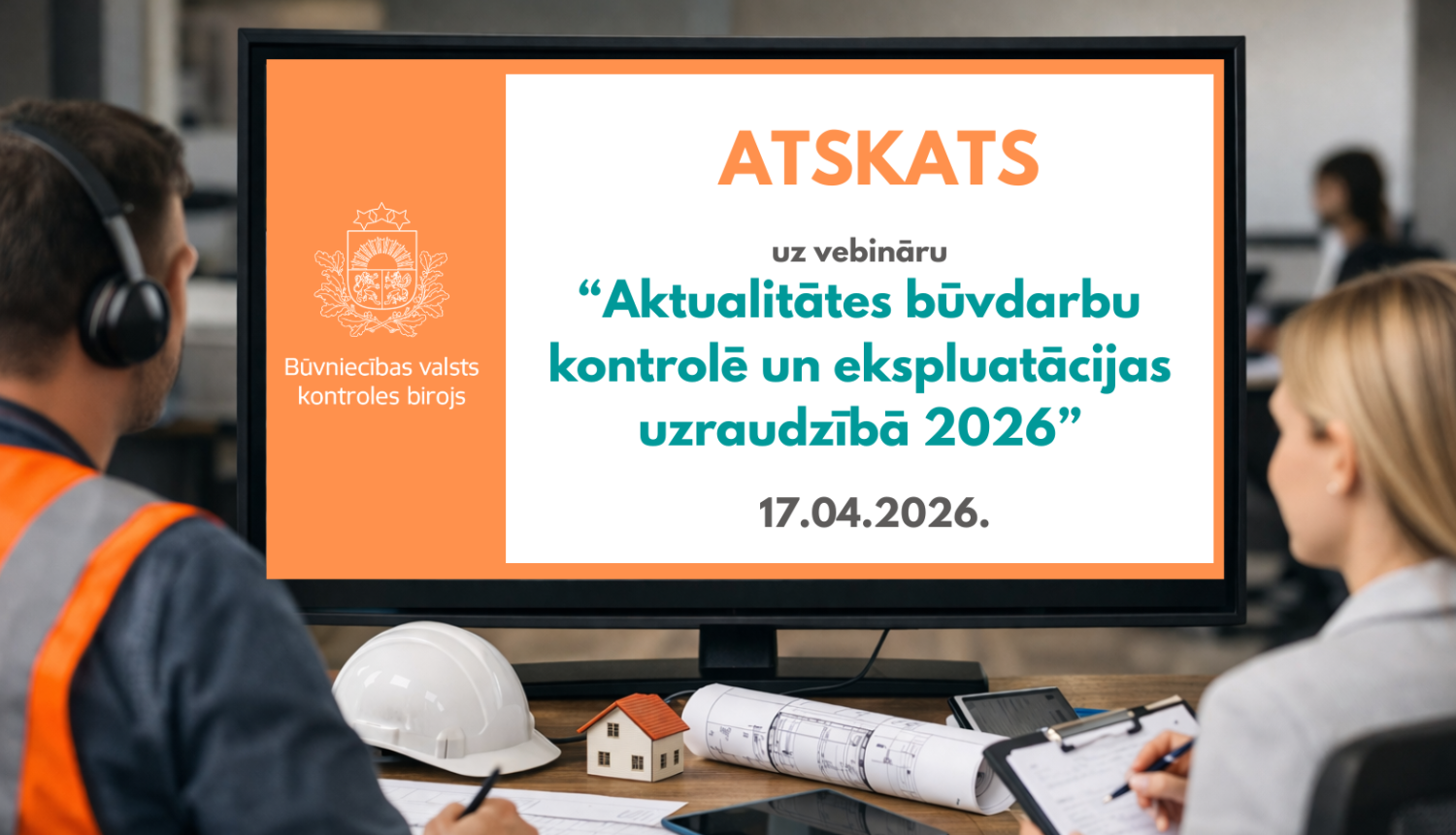 Divi cilvēki birojā skatās uz datora monitoru. Uz ekrāna redzams paziņojums ar Būvniecības valsts kontroles biroja logo un tekstu: “Atskats uz vebināru ‘Aktualitātes būvdarbu kontrolē un ekspluatācijas uzraudzībā 2026’”, datums – 17.04.2026. Uz galda priekšplānā redzama ķivere, rasējumi un neliels mājas makets.