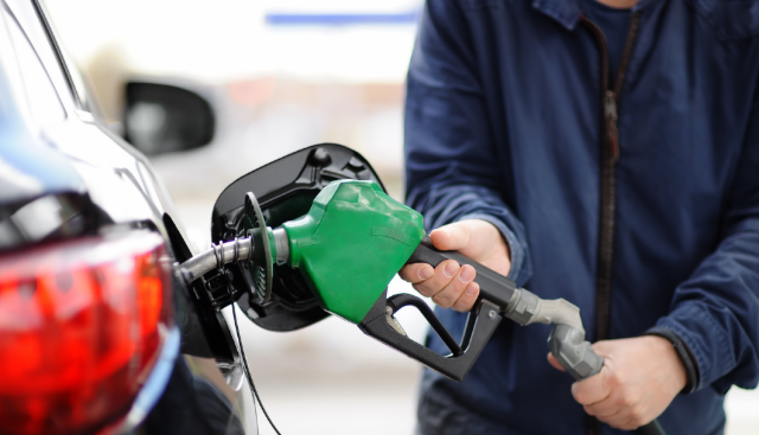 Cilvēks uzpilda auto degvielu