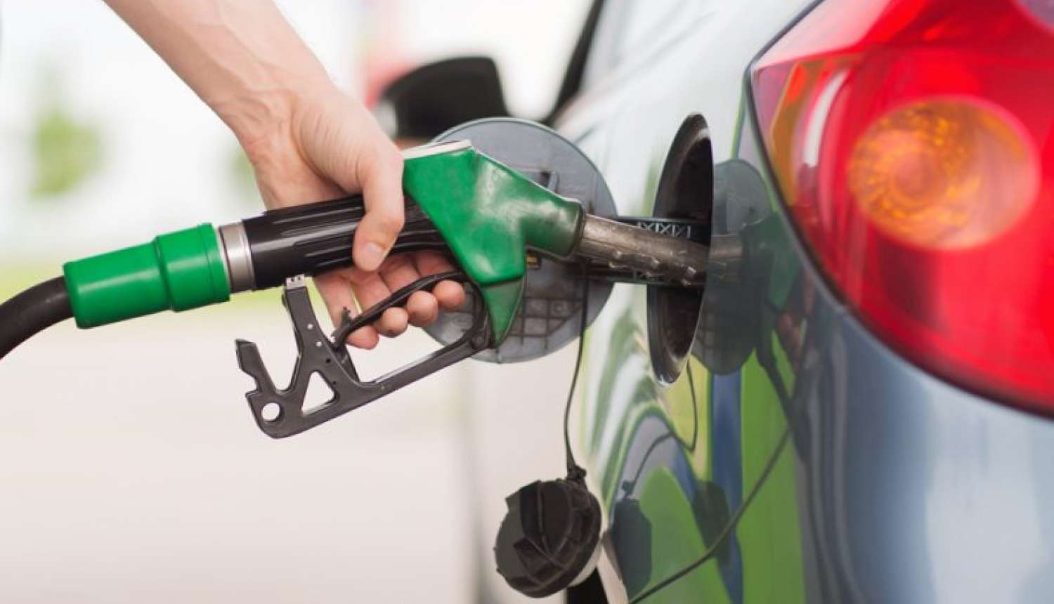 Foto ar automašīnas degvielas bākā ievietotu degvielas pistoli