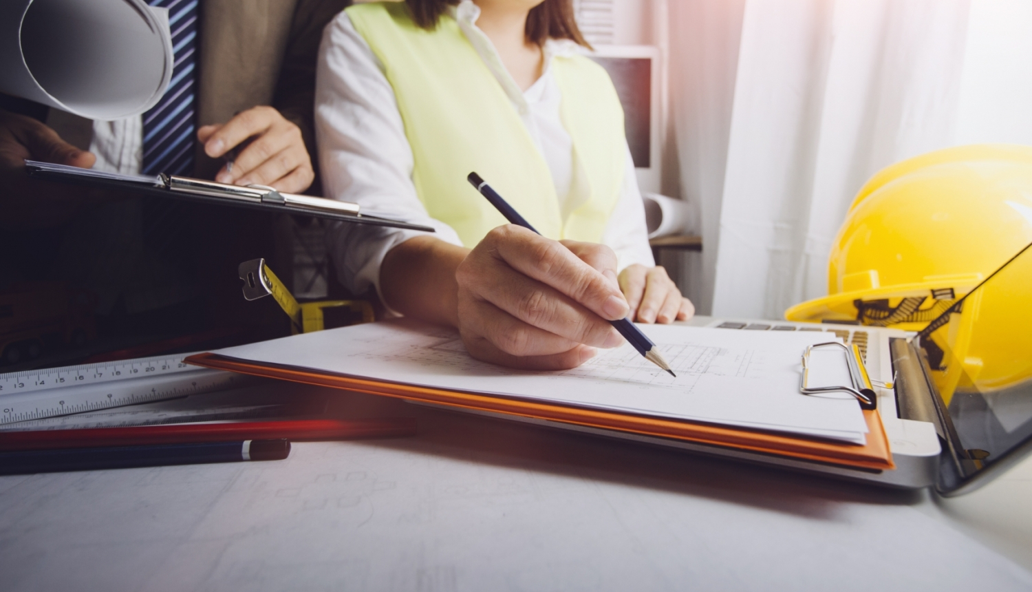 roka ar piezīmju papīru un pildspalvu